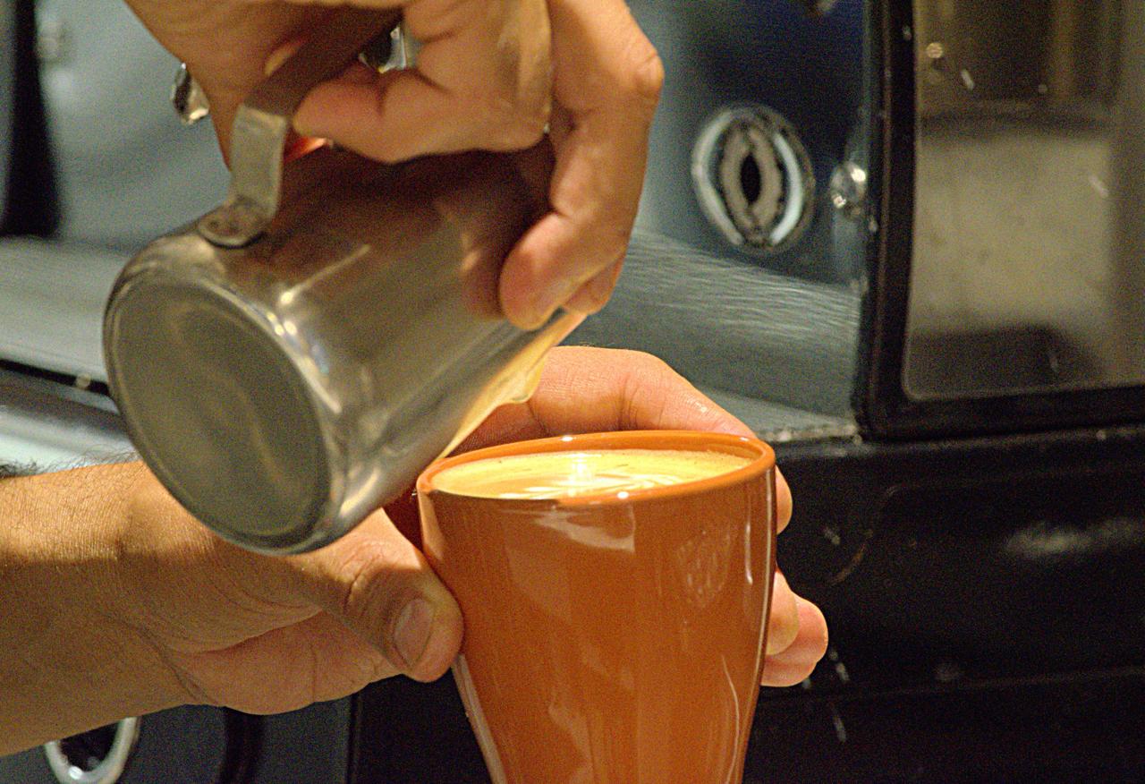 A flat white being poured at Cegin Café